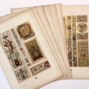 May include: A collection of vintage paper prints titled La Peinture Décorative, featuring intricate illustrations of classical figures, ornate scrollwork, and floral motifs in shades of gold, brown, and cream. The pages are layered, showing detailed decorative art.