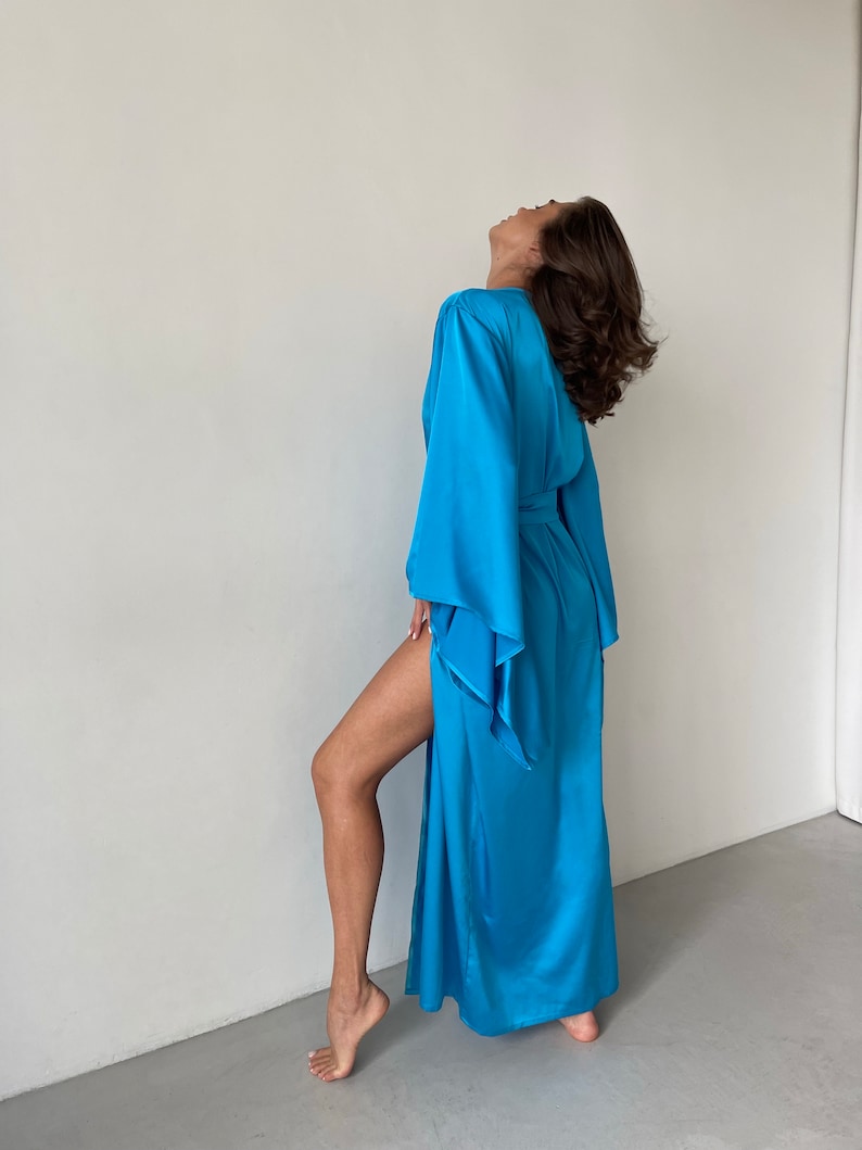 May include: A long, flowing, light blue satin robe with wide sleeves and a tie belt.