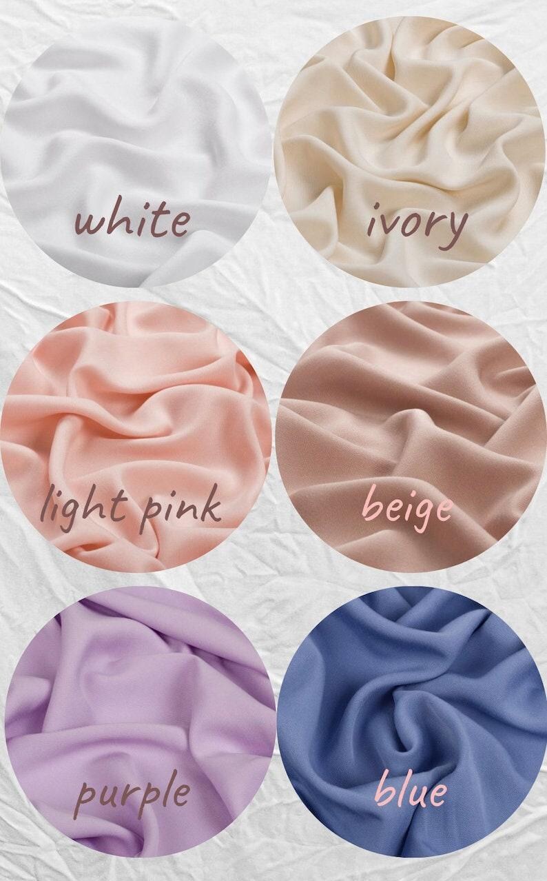May include: A collection of fabric swatches in various colors, including white, ivory, light pink, beige, purple, and blue. Each color is displayed in a circular shape with the color name written on it.