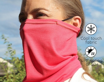 May include: A pink face mask made of a cool touch fabric with a UPF rating of 50+. The mask is worn by a person and covers the nose and mouth.