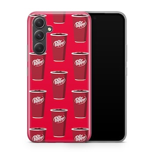 Puede incluir: Una funda de tel&eacute;fono roja con un patr&oacute;n repetido de vasos de refresco Dr. Pepper. Los vasos son rojos con bordes blancos y el logotipo de Dr. Pepper. La funda est&aacute; sobre un smartphone negro.