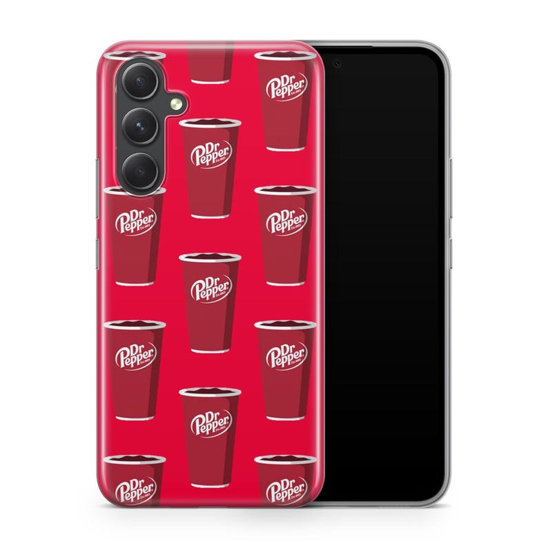 Puede incluir: Una funda de tel&eacute;fono roja con un patr&oacute;n repetido de vasos de refresco Dr. Pepper. Los vasos son rojos con bordes blancos y el logotipo de Dr. Pepper. La funda est&aacute; sobre un smartphone negro.