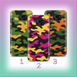 Puede incluir: Tres fundas para teléfono con diseños de camuflaje. Las fundas presentan diseños en verde, amarillo y negro; rosa, amarillo y negro; y naranja, verde y negro. Los números 1, 2 y 3 están debajo.