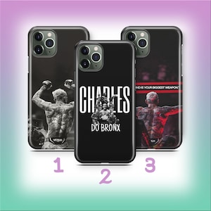 May include: Three black phone cases with different designs. One case features a black and white image of a fighter. Another case has the name "CHARLES DO BRONX" in white. The third case has a fighter with the text "MIND IS YOUR BIGGEST WEAPON."