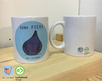 Pode incluir: Caneca de cerâmica branca com um círculo azul e o texto "SONO FICO!" em preto. Dentro do círculo há um desenho animado de uma figo roxo. O texto "@IL_CULOMBO" está abaixo do figo. A caneca está sobre uma superfície de madeira.