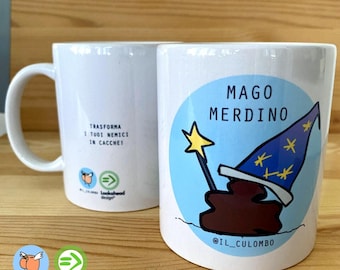 Pode incluir: Caneca de cerâmica branca com uma ilustração azul e branca de um mago com um chapéu de cocó marrom e uma varinha amarela. O texto "MAGO MERDINO" está acima do mago e "@IL_CULOMBO" está abaixo do mago. A parte de trás da caneca tem o texto "TRASFORMA I TUOI NEMICI IN CACCHE!" e um logotipo com o texto "Lookahead design" e um pássaro com um chapéu de cocó.
