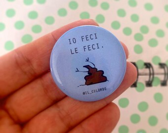 Pode incluir: Um botão azul claro com o texto italiano "IO FECI LE FECI." e uma ilustração de desenho animado de uma pilha de cocó. O botão também inclui o texto "@IL_CULOMBO".