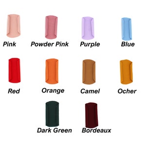 May include: A collection of ten fabric samples in various colors, including pink, powder pink, purple, blue, red, orange, camel, ocher, dark green, and bordeaux. Each sample is labeled with its respective color name in a bold, sans-serif font.