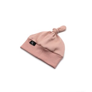 May include: A light pink baby beanie hat with a ribbed crown and a knotted top. The hat features a folded brim and a small black label with white text. The hat is made of a soft, stretchy material.