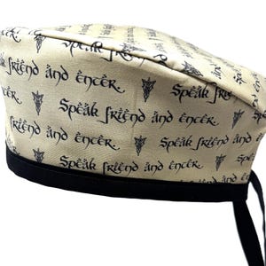May include: A beige fabric hat with a black ribbon and the text "Speak friend and enter" repeated in a black script font.
