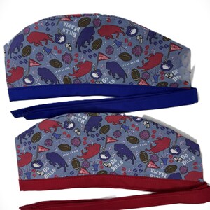 May include: Two scrub caps with a light blue background, patterned with red and blue buffalo, footballs, and flags. The caps have blue and red bands and ties, with the text "Bills Mafia" and "Go Bills".