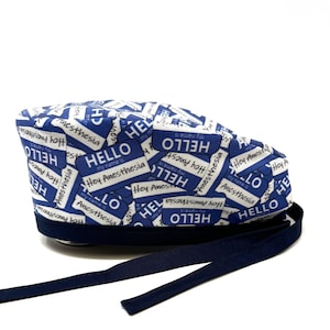 Może przedstawiać: Niebieski i biały czep chirurgiczny z granatowym troczkiem. Czep ma powtarzający się wzór identyfikatorów z napisem "Hello" i "Hey Anesthesia".