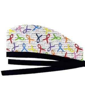 May include: A white surgical scrub cap with a pattern of colorful ribbons and the words "fight alone" repeated across the fabric. The cap has a black band and long black ties.