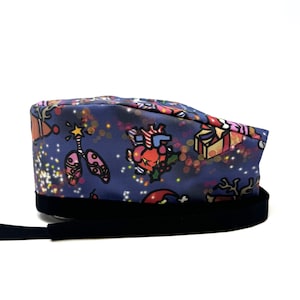 May include: A blue scrub hat with a Christmas-themed print featuring reindeer, presents, candy canes, and a heart. The hat has a black elastic band.