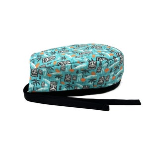 Może przedstawiać: Turkusowy chirurgiczny czepek z gumką w kolorze czarnym. Czepek ma powtarzający się wzór tiki, palm i ananasów.