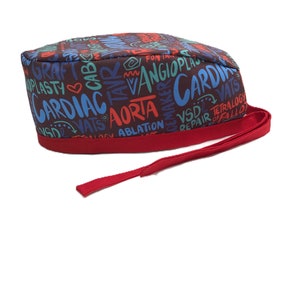 Może przedstawiać: Brązowy czepek chirurgiczny z czerwonym sznurkiem. Czepek jest pokryty kolorowymi terminami medycznymi, w tym "Cardiac", "Aorta", "Angioplasty" i "VATS".