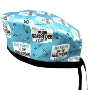 Może przedstawiać: Niebieski i biały chirurgiczny czepek z czarnymi sznurkami. Czepek ma powtarzający się wzór strzykawek i napis "be nice to the bartender".