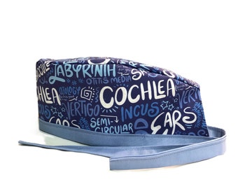 May include: Blue surgical scrub hat with a white print of medical terms related to the ear, including "labyrinth", "cochlea", "vertigo", "incus", and "semi-circular".