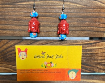 Los pendientes rojos y azules de Buda cuelgan