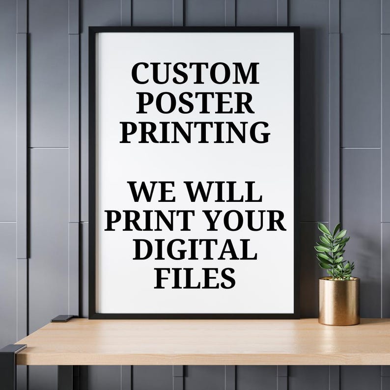 K&ouml;nnte beinhalten: Ein gerahmtes Poster mit dem Text "CUSTOM POSTER PRINTING" und "WE WILL PRINT YOUR DIGITAL FILES" in Schwarz. Eine kleine Topfpflanze in einem goldenen Beh&auml;lter steht auf einem Holzregal.