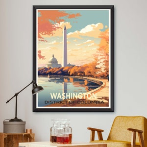 May include: A framed art print featuring a stylized illustration of Washington, D.C. The artwork depicts the Capitol Building, Washington Monument, and a waterfront scene with autumn foliage. The print has a black frame and the text "WASHINGTON DISTRICT OF COLUMBIA".