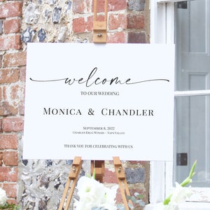 May include: White wedding welcome sign with black calligraphy text. The sign reads "Welcome to our wedding, Monica & Chandler, September 8, 2022, Charles Krug Winery - Napa Valley, Thank you for celebrating with us."