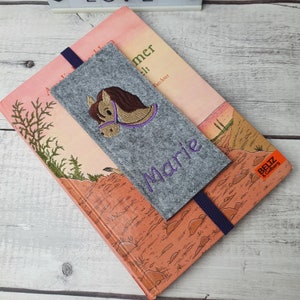 May include: Gray felt bookmark with a purple embroidered horse and the name "Marie" in purple thread.