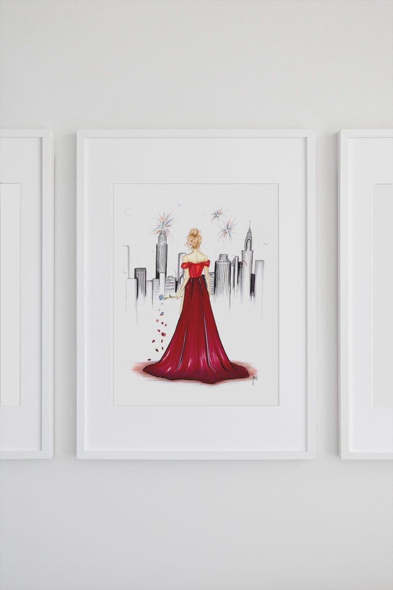 May include: Illustration of a woman in a red off-the-shoulder gown, holding a blue flower, with a cityscape backdrop. The artwork is framed in a white border, with a minimalist style. The artwork is a print.