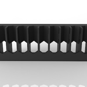 May include: A black, geometric organizer with multiple vertical compartments. The design features a series of hexagonal cutouts along the base, creating a visually interesting and functional storage solution. The organizer is made of a solid, dark material.