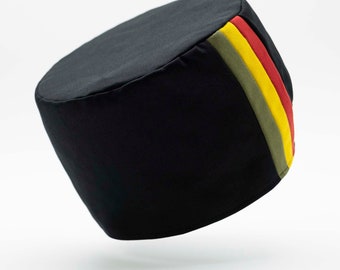 May include: Black fabric chef hat with a green, yellow, and red stripe design.