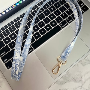 Toile de Jouy-koord | Badge | Sleutel | Air Pods-houderriem | Gouden karabijnsluiting: ca. B 1,5 CM x L44 CM (stoffen band) + L 4,2 CM (sluiting).
