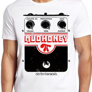 May include: A white short-sleeve t-shirt featuring a graphic print of an effects pedal. The design includes the text MUDHONEY, the pi symbol, and electro-harmonix, with three knobs labelled VOLUME, TONE, and SUSTAIN, plus AMPLIFIER AC, TONE-BYPASS, and INPUT.