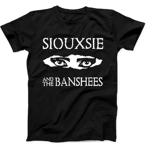 Könnte beinhalten: Ein schwarzes T-Shirt mit kurzen Ärmeln und einem weißen Grafikdruck. Das Design zeigt den Schriftzug SIOUXSIE oben, ein Paar stilisierte Augen in der Mitte und den Schriftzug AND THE BANSHEES direkt unter den Augen.
