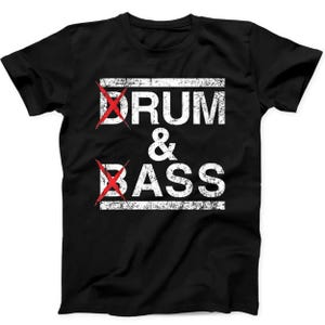 Op de afbeelding: Een zwart t-shirt met korte mouwen en de witte, verweerde tekst DRUM & BASS in het midden op de borst. De letter D in beide woorden is doorgestreept met een felrode X. Het ontwerp is omlijst door twee horizontale witte verweerde lijnen.