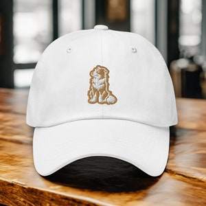 May include: White baseball cap with a brown embroidered dog design.