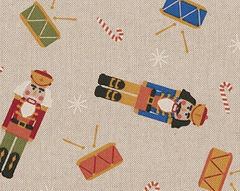 May include: A beige fabric with a repeating pattern of nutcrackers, drums, and candy canes. The nutcrackers are in red, blue, and gold. The drums are in red, blue, and gold. The candy canes are in red and white.