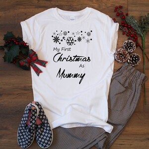 May include: White t-shirt with the text "My First Christmas As Mummy" and a design of snowflakes and stars.