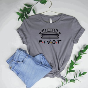May include: Gray t-shirt with a black outline of a couch and the word "PIVOT" with colorful dots.