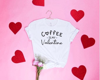 Könnte beinhalten: Weißes T-Shirt mit einem schwarzen Aufdruck, der "Coffee is my Valentine" sagt, wobei ein Herz das "o" in Coffee ersetzt.
