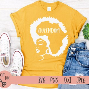 May include: A yellow t-shirt with a white silhouette of a woman's face and the word "QUEENDOM" above her head.