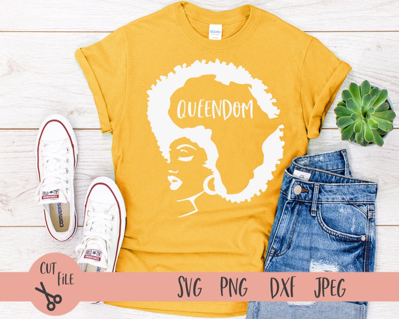 May include: A yellow t-shirt with a white silhouette of a woman's face and the word "QUEENDOM" above her head.