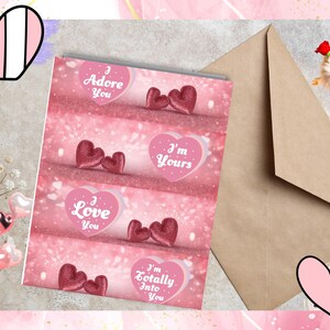 Può includere: Quattro biglietti di San Valentino rosa e bianchi con messaggi diversi. Ogni biglietto presenta uno sfondo rosa con un effetto glitter e due cuori rosa. I messaggi sui biglietti sono "Ti adoro", "Sono tuo", "Ti amo" e "Sono totalmente innamorato di te".