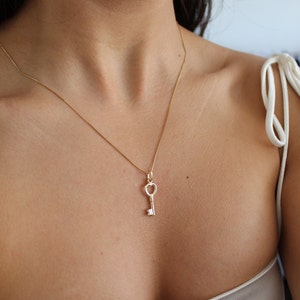 Peut inclure: Un collier en cha&icirc;ne dor&eacute;e avec un pendentif en forme de cl&eacute; de c&oelig;ur.