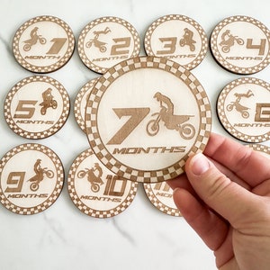 Puede incluir: Conjunto de diez discos de madera para hitos de beb&eacute; con un dise&ntilde;o de piloto de motocross. Cada disco tiene un n&uacute;mero del 1 al 10 y la palabra "MONTHS" impresa en &eacute;l.
