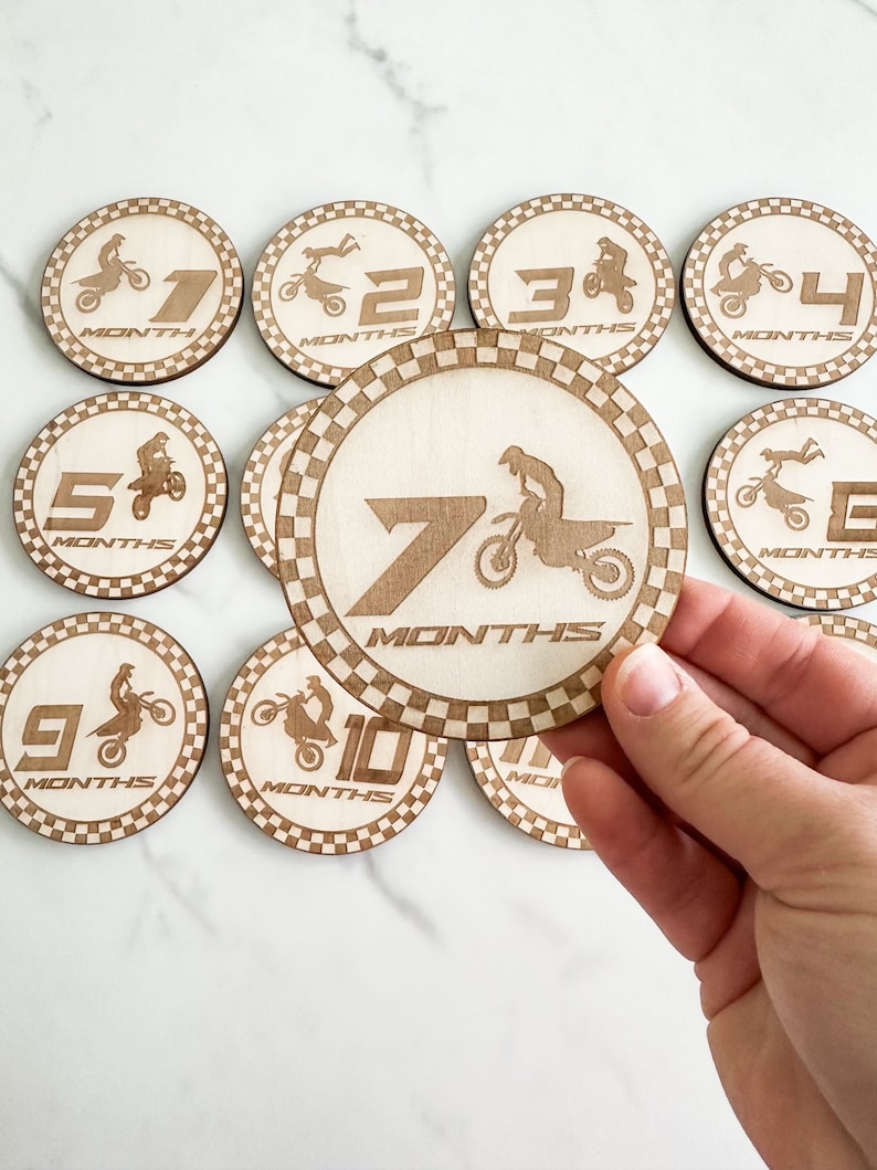 Puede incluir: Conjunto de diez discos de madera para hitos de beb&eacute; con un dise&ntilde;o de piloto de motocross. Cada disco tiene un n&uacute;mero del 1 al 10 y la palabra "MONTHS" impresa en &eacute;l.