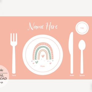 May include: A pink placemat with a rainbow design and the words "Name Here" at the top. The placemat also includes labels for a plate, fork, knife, spoon, and cup.