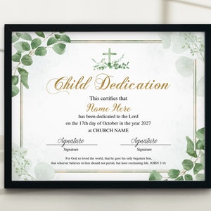 May include: A framed Child Dedication certificate with a black frame. The certificate has gold lettering and a cross graphic. Green eucalyptus leaves and watercolor accents decorate the edges. The text includes "Name Here" and "CHURCH NAME".
