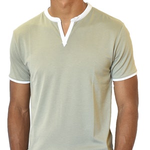 Puede incluir: Una camiseta verde claro de manga corta con cuello en V y ribete blanco en el cuello y las mangas. La camiseta es de material suave y de estilo casual.