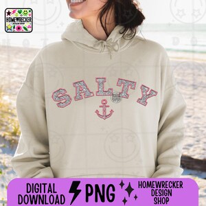 Op de afbeelding: Een beige hoodie met het woord "SALTY" in roze en zilveren glitterletters, met een roze ankerafbeelding. De hoodie heeft ook de tekst "DIGITAL DOWNLOAD PNG" en "HOMEWRECKER DESIGN SHOP".