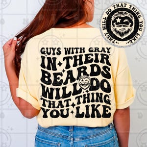 May include: A light yellow t-shirt with the text "GUYS WITH GRAY IN THEIR BEARDS WILL DO THAT THING YOU LIKE" in black. The shirt also features a graphic of a bearded man. The shirt is being worn by a person.